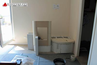 Fase 3: la posa prosegue con il collocamento delle maioliche di rivestimento della camera di combustione, e della panca in ceramica.
