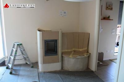 Fase 4: la costruzione prosegue con la posa in opera dello schienale, precedentemente assemblato, ed il posizionamento della portina. Parallelamente inizia la costruzione interna della camera di combustione e dei giri di fumo.