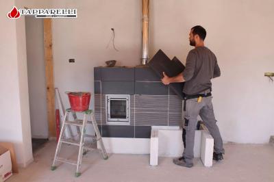 Fase 5. - Patrizio Tapparelli anche in questa installazione è impegnato in prima persona. Allacciata la stufa alla canna fumaria, si procede con la posa delle coperture. Fase 5.