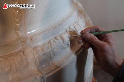Fase 7. - Dopo aver ricreato i pezzi mancanti, averli collocati sulla stufa, dopo aver stuccato con prodotti adeguati ogni parte che lo richiedeva, il restauro è proseguito con il ritocco pittorico. Fase 7.